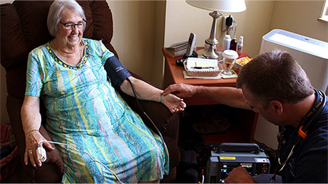 Nurse caring for elderly woman in her home