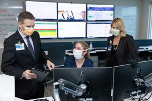 Professionals with face masks looking at computer screens